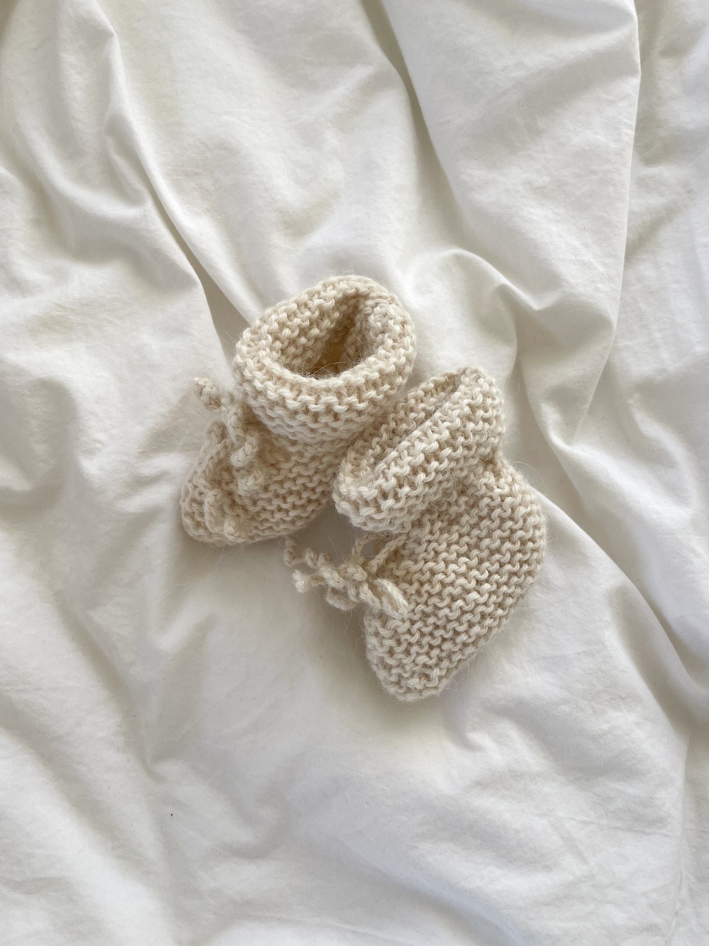 Håndstrikkede råhvide futter, uld str. 0-2 mdr